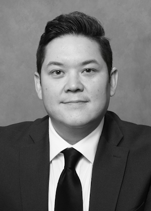 Kevin Lowe, structured settlement and annuity expert, in a black and white color palette, wearing a dark suit, white shirt, and dark tie.