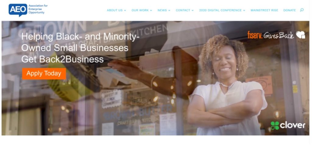 Restaurateur smiling in front of her restaurant.